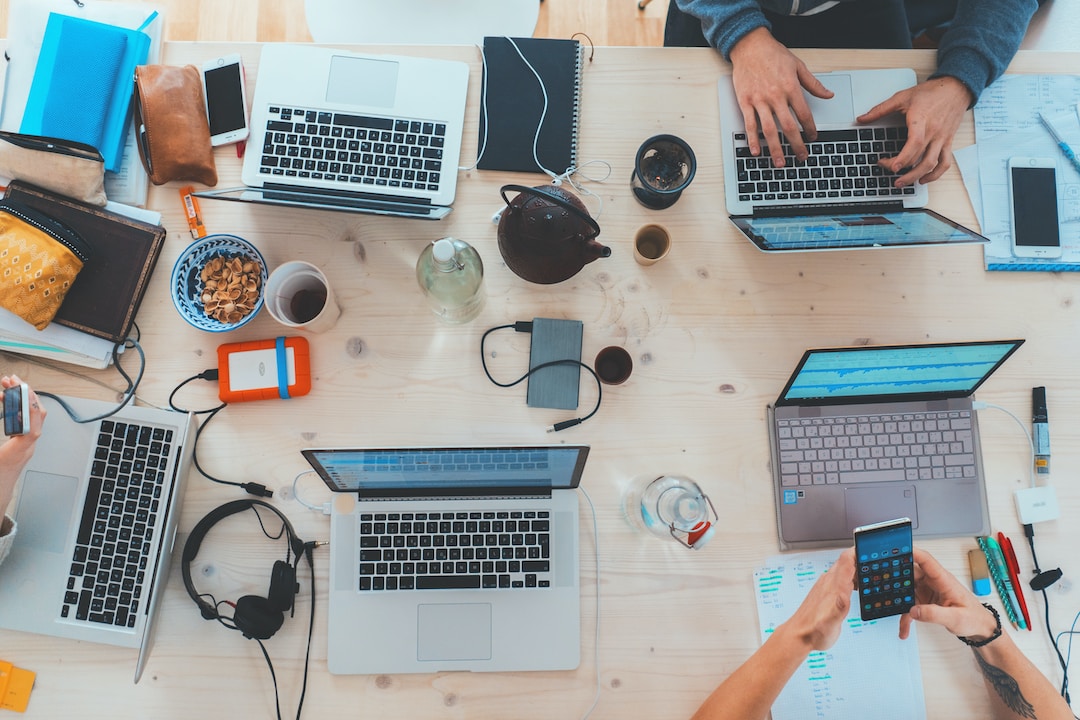 Five laptop computers on a desk to represent how revenue leakage can be detected through the use of technology